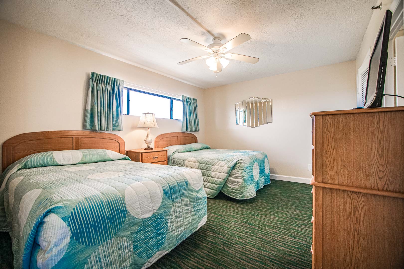 A bedroom with double beds at VRI's Landmark Holiday Beach Resort in Panama City, Florida.